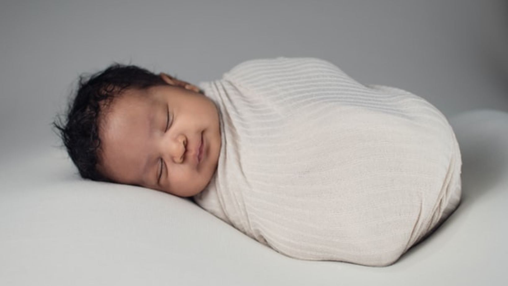 A baby bundled up in a blanket